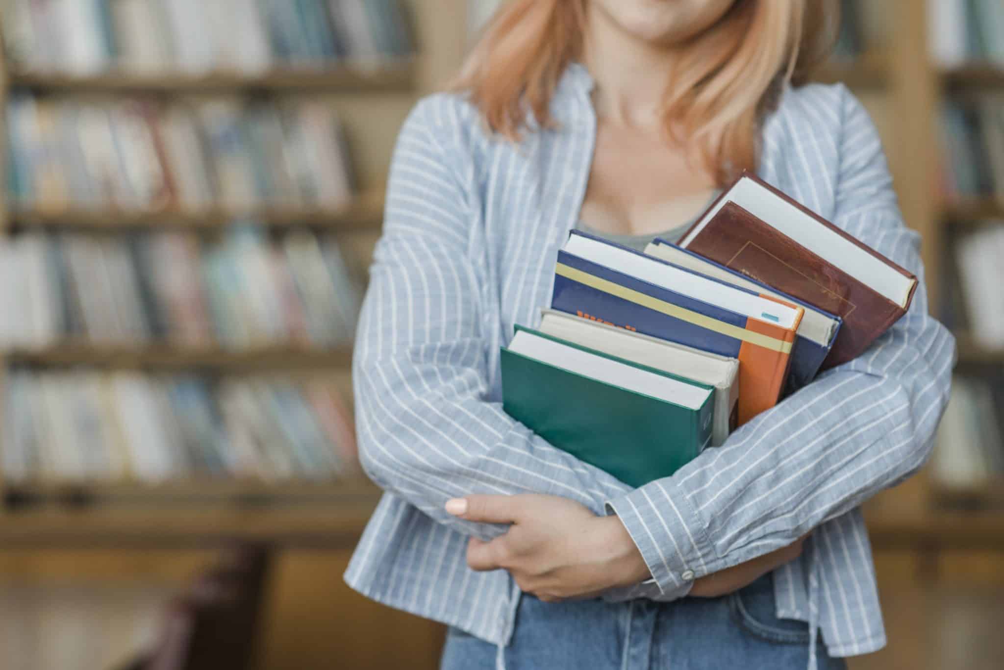 studente di università con libri in una biblioteca